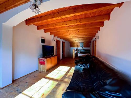 a living room with a couch and a wooden ceiling at Cabanita in Întorsura Buzăului