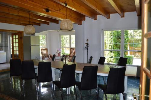 uma sala de jantar com uma grande mesa de madeira e cadeiras em Cabanita em Întorsura Buzăului