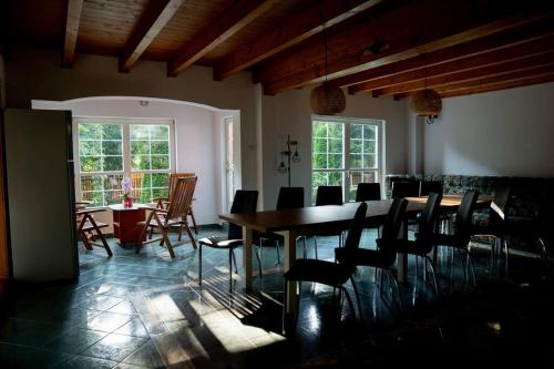 a dining room with a table and chairs and windows at Cabanita in Întorsura Buzăului