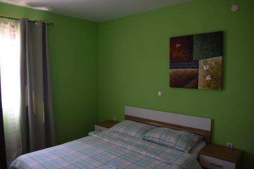 una camera con letto e parete verde di Apartmani Tomljenović a Senj