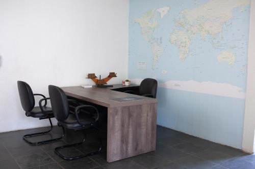 - un bureau avec un bureau, des chaises et une carte du monde dans l'établissement Apartamentos na região Central Cobertura e 2 quartos, à Ponta Grossa