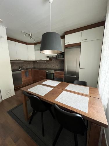eine Küche mit einem Holztisch und schwarzen Stühlen in der Unterkunft Rauhallinen paritalo, Sauna, Terassi, Grilli in Lehmonaho