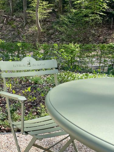 a table and a table and a table and a chair at La Villa du Pré Du Cerf in Spa