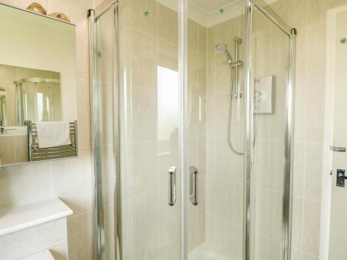 a shower with a glass door in a bathroom at Gull Cottage in Lowestoft