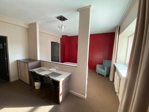 a room with a desk and a red wall at Ulpan Mini Hotel in Astana