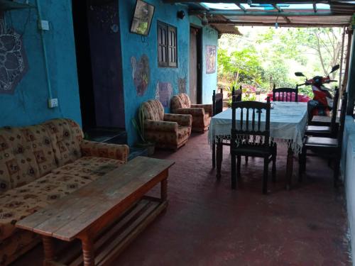 a living room with a table and a table and chairs at Cozy House Hostel in Ella