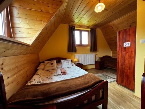 a bedroom with a large bed in a wooden house at POD ROŻKAMI in Cisna