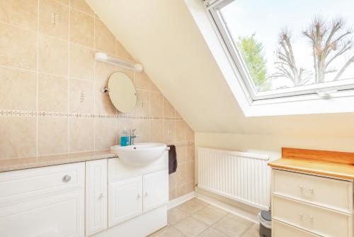 a bathroom with a sink and a window at Elvington Cottage - Family-friendly cheerful house at the heart of the Cotswolds in Bourton on the Water
