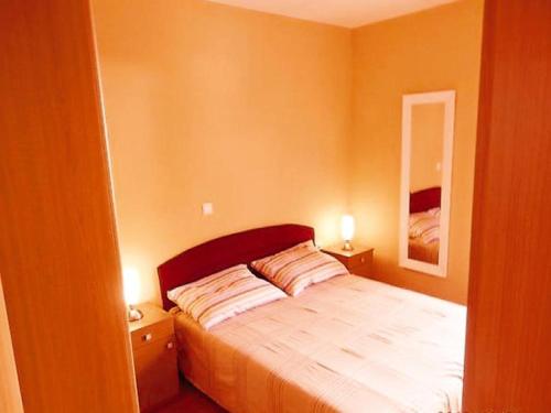 1 dormitorio con 1 cama con 2 mesitas de noche y espejo en Apartments St Rialto, en Jelsa