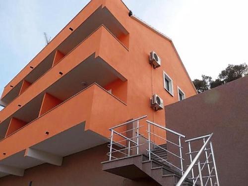 an orange building with stairs on the side of it at Apartments St Rialto in Jelsa