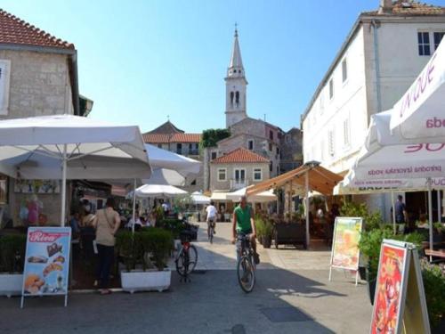 a man riding a bike through an outdoor market at Apartments St Rialto in Jelsa