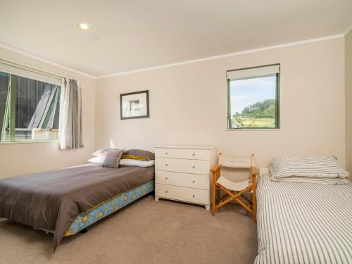 une chambre avec un lit, une commode et une fenêtre dans l'établissement Sandy Feet Retreat - Cooks Beach Holiday Home, à Cooks Beach