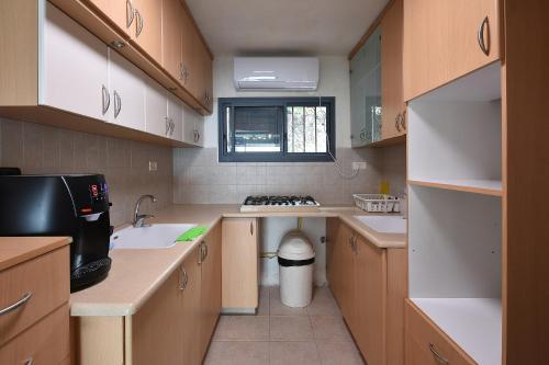 a small kitchen with a sink and a stove at Levication Multiple Apartments - Family Stays Tiberias in Tiberias