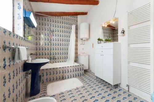 a bathroom with a blue and white tiled wall at Studio and Room Tea in Rovinj