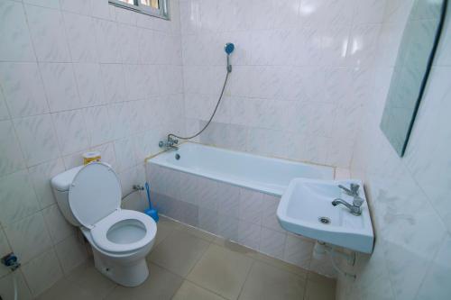 y baño con aseo y lavamanos. en 3 bedroom Apartment en Dar es Salaam