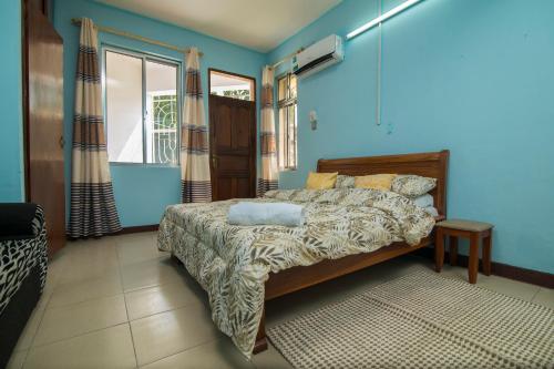 1 dormitorio con 1 cama con paredes azules en 3 bedroom Apartment en Dar es Salaam