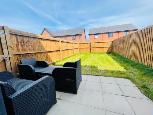 a patio with two chairs and a fence at Barry Waterfront Stays - ENTIRE 3 BED PROPERTY in Barry
