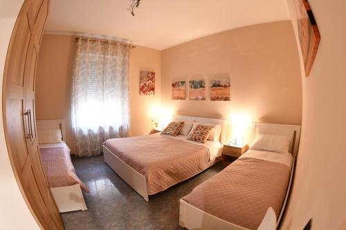 1 dormitorio con 2 camas y ventana en Affitti turistici: OASI FELICE, en Torrile
