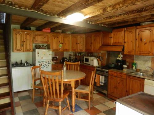 a kitchen with wooden cabinets and a table and chairs at @gatetothewild in Coreglia Ligure