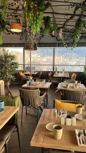 a restaurant with tables and chairs and a view at Hôtel Des Gouverneurs in Bastia