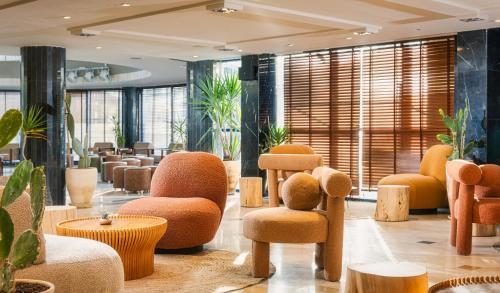 a lobby with chairs and tables and plants at Horizon Red Sea in Eilat