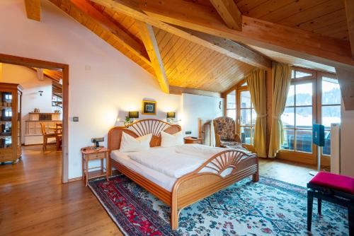 ein Schlafzimmer mit einem großen Bett und einer Holzdecke in der Unterkunft Ferienwohnung Edelweiß mit Bergbahn unlimited in Obermaiselstein