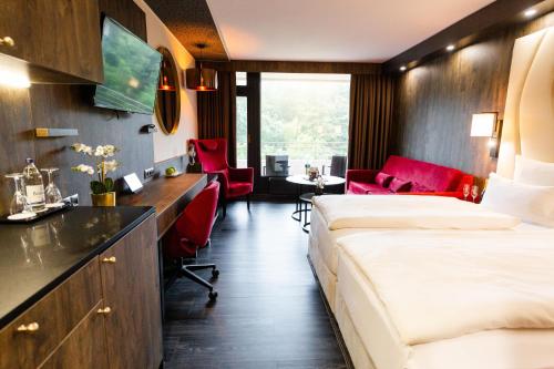 a hotel room with two beds and a desk at PLAZA Premium Timmendorfer Strand in Timmendorfer Strand
