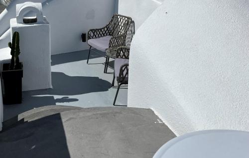 a stairway with two chairs and a cactus at Aidos Villa Santorini in Megalochori