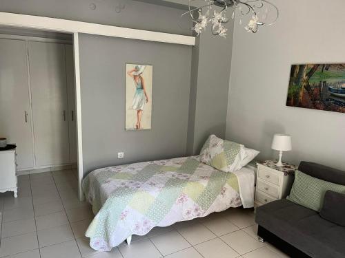 a bedroom with a bed and a couch and a painting at Sea view Apartments near Athens Airport 02 in Artemida