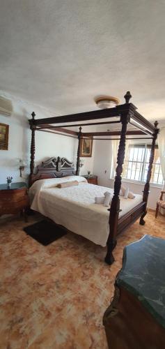 1 dormitorio con cama con dosel en una habitación en Villa Don Giovanni Fuengirola, Piscina Privada y vistas al mar y a la Montaña en Fuengirola