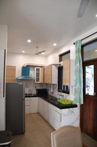 uma cozinha com armários brancos e um balcão preto em Nirvan em Varca