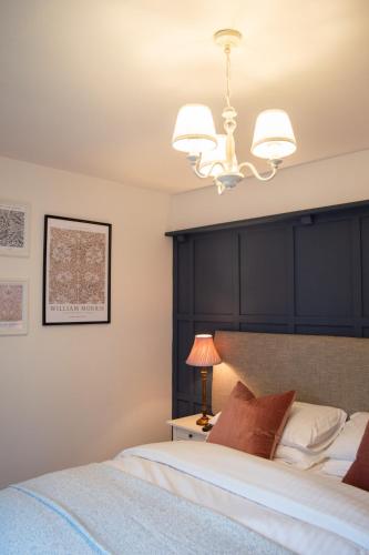 a bedroom with a large bed and a chandelier at The Pack Horse Exmoor National Park Allerford Riverside Cottage & Apartments in Minehead