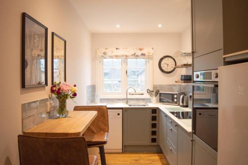 a kitchen with a wooden table and a counter top at The Pack Horse Exmoor National Park Allerford Riverside Cottage & Apartments in Minehead