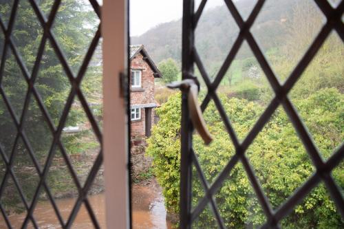 a view from the window of a house at The Pack Horse Exmoor National Park Allerford Riverside Cottage & Apartments in Minehead