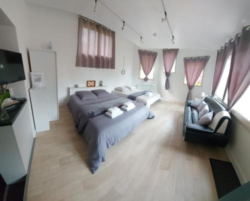 1 Schlafzimmer mit 2 Betten und einem Sofa in der Unterkunft Studio 6 in Le Boupère