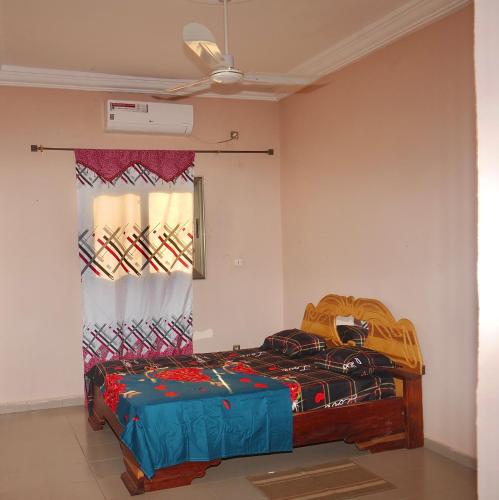 a bedroom with a bed and a window at Appartement et Chambres in Bamako