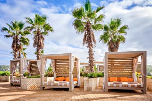 a row of beds with palm trees in the background at Pullman Mazagan Royal Golf & Spa in El Jadida