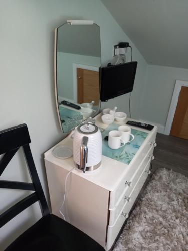 a mirror sitting on top of a dresser with cups at Flat 4, 43 Part Street in Southport