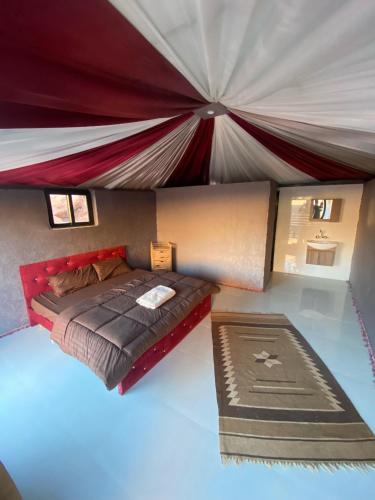 a room with a bed and a large tent at Wadi Rum Moon Light Camp in Wadi Rum