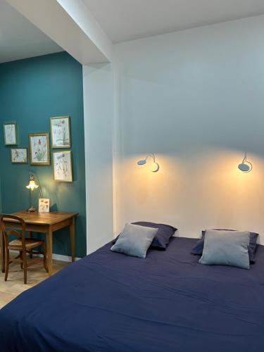 um quarto azul com uma cama e uma secretária em Magnifique Appartement l'Aigrette em Dieppe