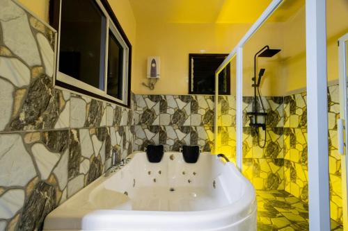 a bathroom with a white sink and mosaic tiles at Loboc Cool River Resort in Loboc