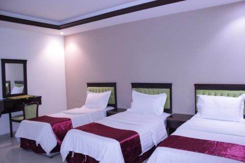 Altamyoiz Sirved Apartments في جدة: غرفه فندقيه سريرين وبيانو