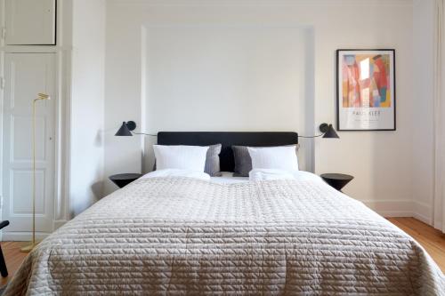 a bedroom with a large bed with a black headboard at Famous Lakes Apt - City Central in Copenhagen