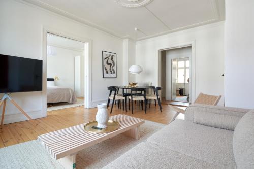 uma sala de estar com um sofá e uma mesa em Famous Lakes Apt - City Central em Copenhague