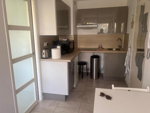 eine kleine Küche mit einer Spüle und einer Mikrowelle in der Unterkunft Appartement à Bandol in Bandol