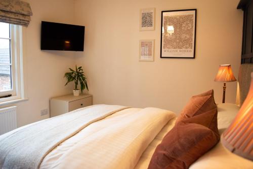 a bedroom with a bed and a tv on the wall at The Pack Horse Exmoor National Park Allerford Riverside Cottage & Apartments in Minehead