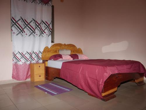 a bedroom with a bed with a wooden bed frame at Appartement et Chambres in Bamako