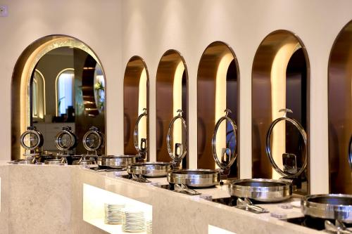 uma fila de panelas e frigideiras num balcão com espelhos em Eldis Regent Hotel em Daegu