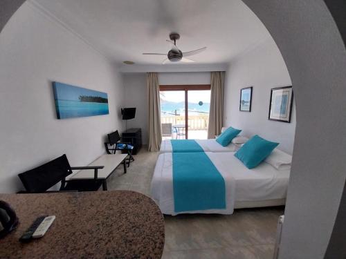 Habitación de hotel con cama, mesa y sillas en Apartamentos Torre Playa en Puerto Pollensa
