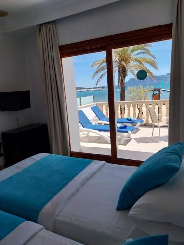 a bedroom with a bed and a view of the ocean at Apartamentos Torre Playa in Port de Pollensa